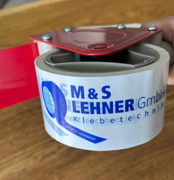Bedrucktes Klebeband mit Logo der M&S Lehner GmbH auf Karton, PVC-Klebeband für Versand und Verpackung.